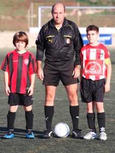 El colegiado con los capitanes del partido