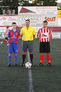 El colegiado con los capitanes del partido