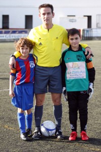 El colegiado con los capitanes del partido