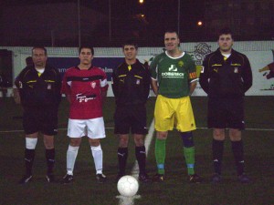 El trio arbitral con los capitanes del partido