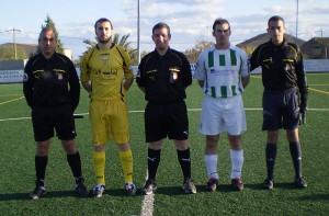 El trio arbitral con los capitanes del partido