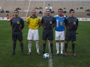 El trío arbitral con los capitanes del partido