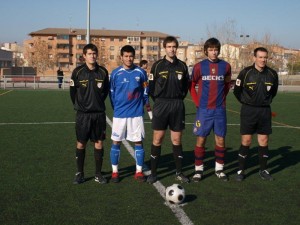 El trío arbitral con los capitanes del partido