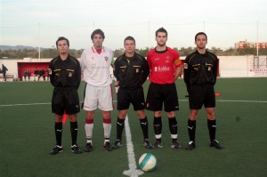 El trio arbitral con los capitanes del partido