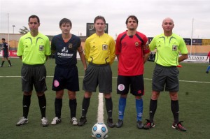 El trío arbitral con los capitanes del partido