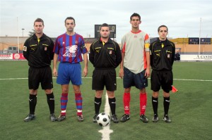 El trío arbitral con los capitanes del partido