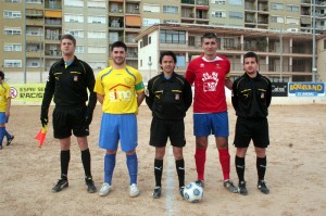 El trío arbitral con los capitanes del partido