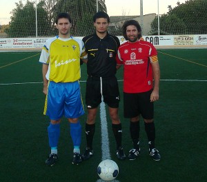 El colegiado con los capitanes del partido