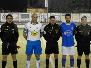 El trío arbitral con los capitanes del partido