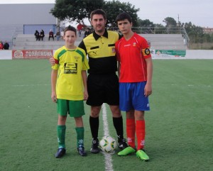 El colegiado con los capitanes del partido