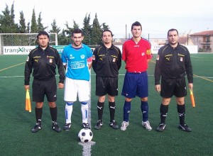 El trio arbitral con los capitanes del partido