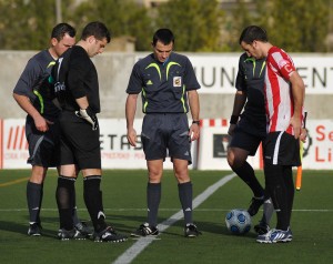 El trio arbitral con los capitanes del partido