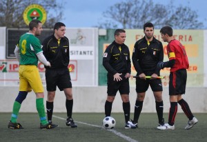 El trio arbitral con los capitanes del partido