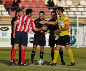 El trio arbitral con los capitanes del partido