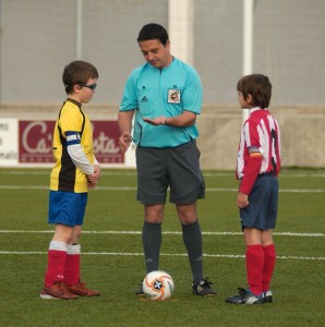 El colegiado con los capitanes del partido