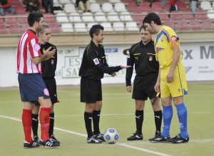 El trio arbitral con los capitanes del partido