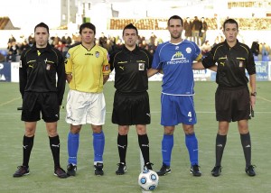 El trio arbitral con los capitanes del partido