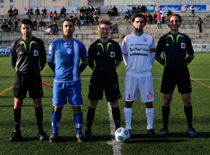 El trio arbitral con los capitanes del partido