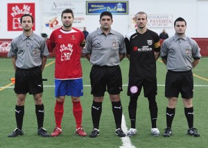 El trio arbitral con los capitanes del partido