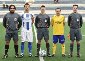 El trío arbitral con los capitanes del partido