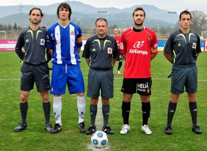 El trio arbitral con los capitanes del partido