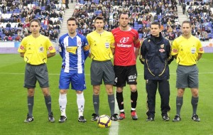 El trio arbitral con los capitanes del partido