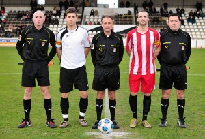 El trio arbitral con los capitanes del partido