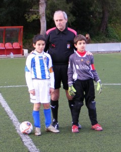 El colegiado con los capitanes del partido