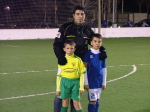 El colegiado con los capitanes del partido