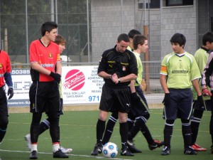 El colegiado con los capitanes del partido