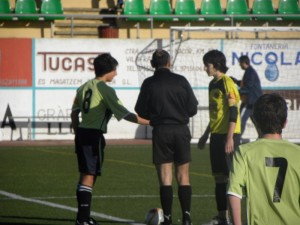 El colegiado con los capitanes del partido