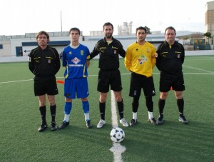 El trio arbitral con los capitanes del partido