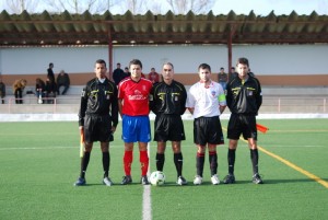 El trio arbitral con los capitanes del partido