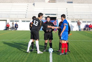 El trio arbitral con los capitanes del partido