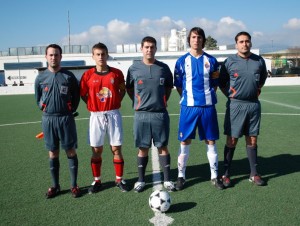 El trio arbitral con los capitanes del partido