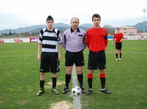 El colegiado con los capitanes del partido