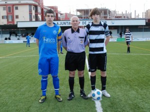 El colegiado con los capitanes del partido