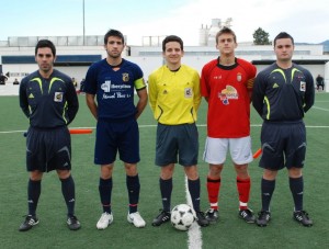 El trío arbitral con los capitanes del partido