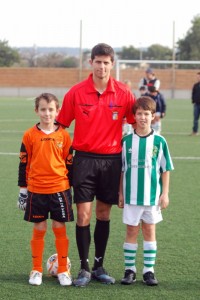 El colegiado con los capitanes del partido