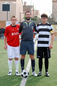 El colegiado con los capitanes del partido