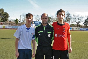 El colegiado con los capitanes del partido