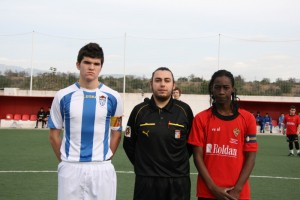 El colegiado del partido con los capitanes de los equipos