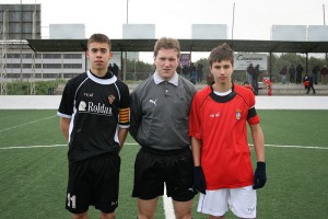 El colegiado con los capitanes del partido