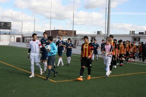 El colegiado saliendo al campo con ambos equipos