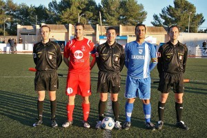 El trio arbitral con los capitanes del partido