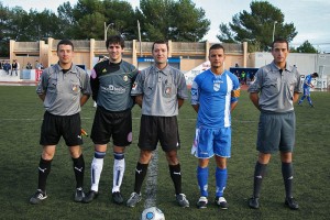 El trio arbitral con los capitanes del partido