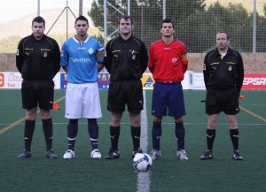 El trio arbitral con los capitanes del partido