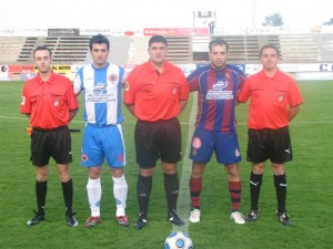 El trio arbitral con los capitanes del partido