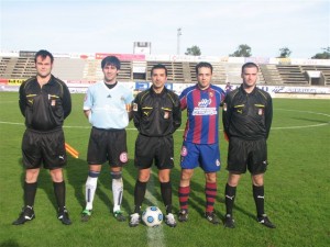 El trio arbitral con los capitanes del partido