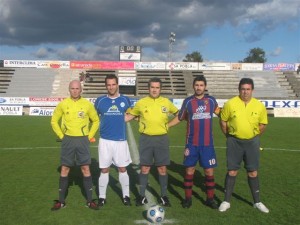 El trio arbitral con los capitanes del partido